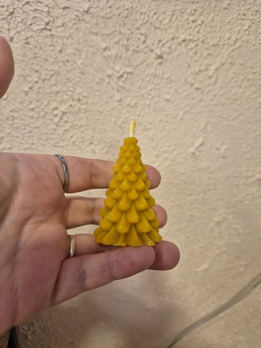 Laikoma rankoje bičių vaško žvakė eglutės formos.