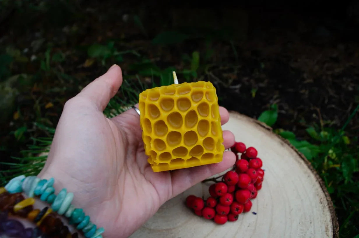 Rankoje laikoma geltona, kubo formos su korio imitacijomis bičių vaško žvakė.