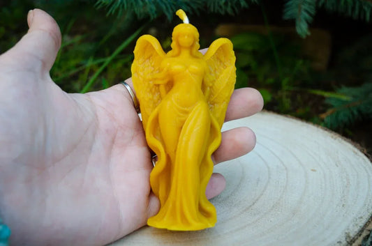 Rankoje laikoma didelė moters angelo žvakė