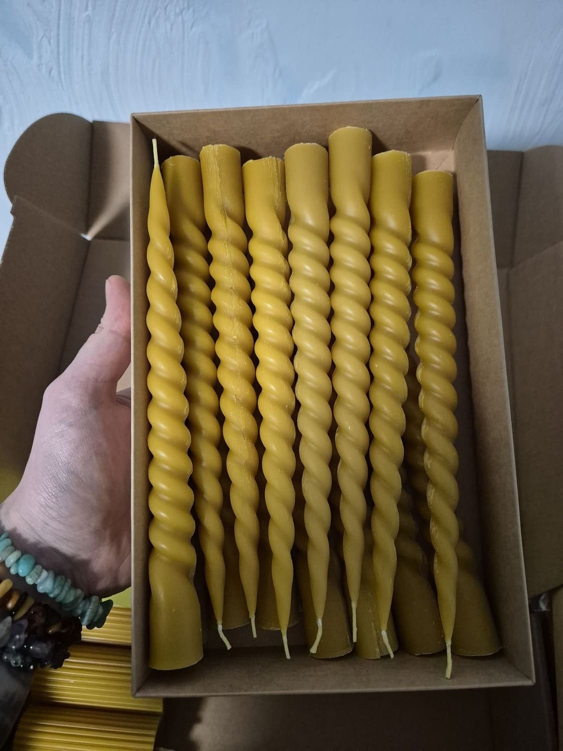 Naturalaus bičių vaško stalo žvakės sudėtos į dežute.