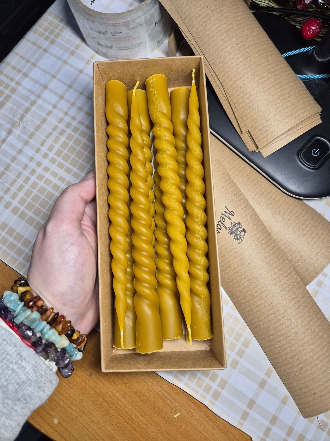 Bičių vaško suktus vakarinės stalo žvakės sudėtos į pakavimo dėžute.