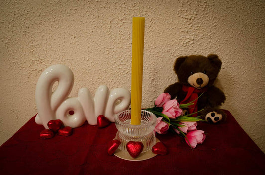 Geltona, cilindrinės formos stalo žvakė.