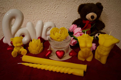 Natūralaus bičių vaško žvakių rinkinys romantiškoje kompozicijoje.