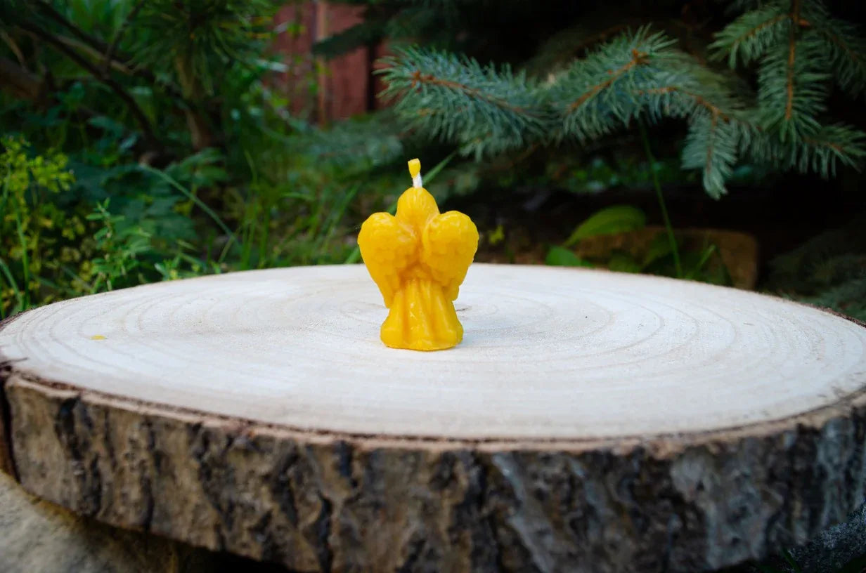 Mažos mergaitės angeliuko žvakutė pastatyta nuagara į žiūrova