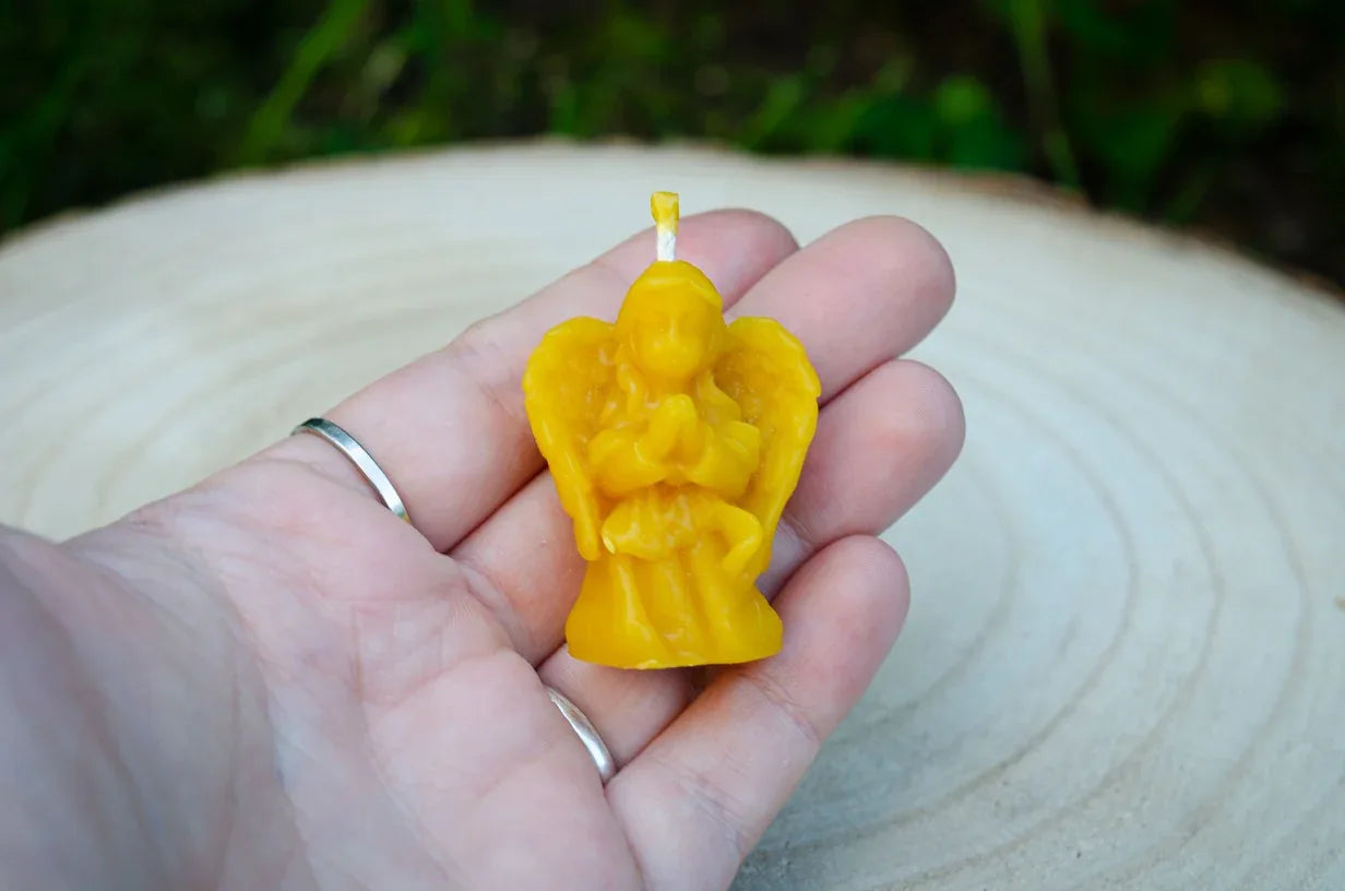 Rankoje laikomas maža angelo žvakutė 