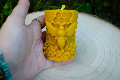 cilindrinė žvakė su didele bite laikoma rankoje