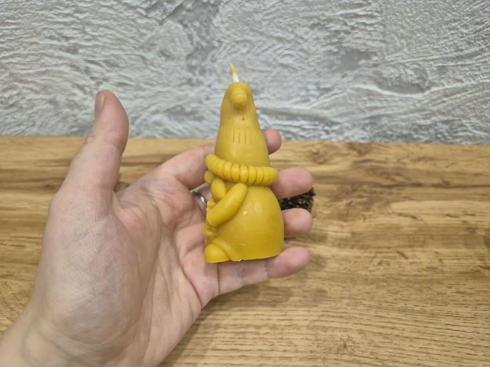 Bičių vaško žvakė elfas laikoma rankoje pasukus į kaire puse.