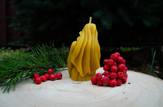 Natūralaus bičių vaško žvakė Motinos laikančios kūdikį formos atsukta nugara į žiūrovą.