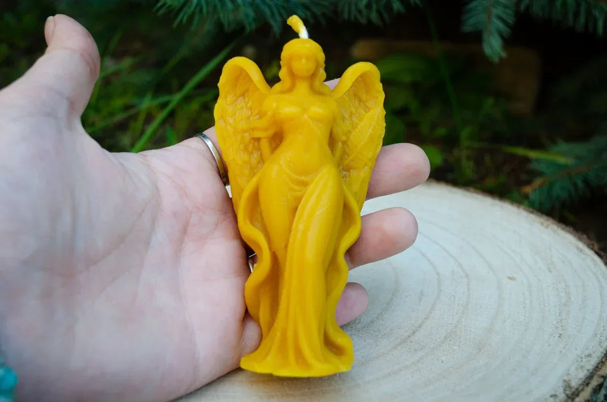 Rankoje laikoma didelė moters angelo žvakė