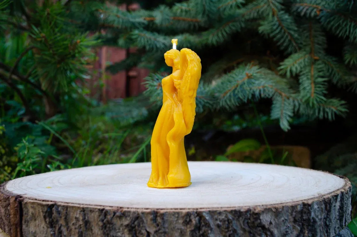 Didelė moters angelo žvakė pastatyta šonu į žiūrova