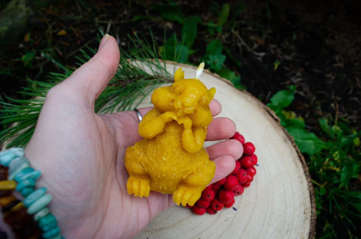 Rankoje laikoma natūralaus bičių vaško žvakė voverės formos.